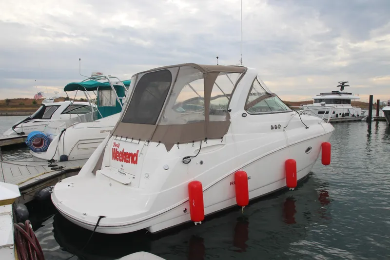 The Image of 2008 Rinker 330 Express Cruiser docked with red fenders, overcast sky. - 0