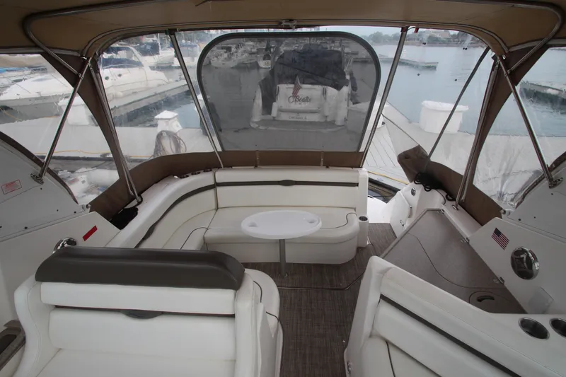 Slide: The Image of 2008 Rinker 330 Express Cruiser interior with seating and table, docked at marina. - 14