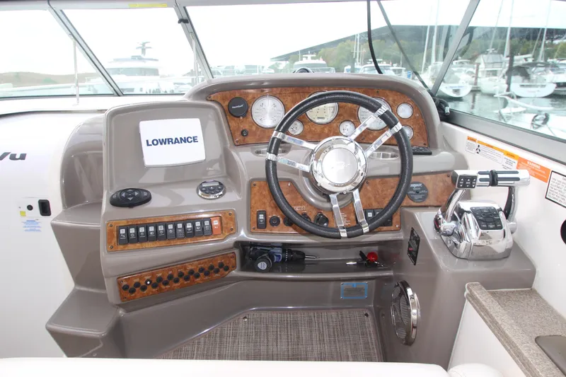 Slide: The Image of 2008 Rinker 330 Express Cruiser helm with steering wheel and navigation controls. - 16