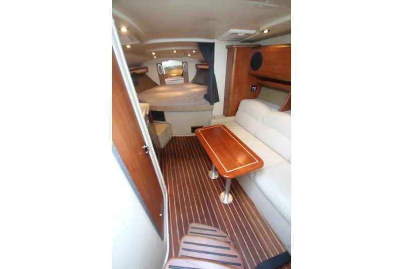 Slide: The Image of 2008 Rinker 330 Express Cruiser interior with wood accents and cozy seating area. - 22