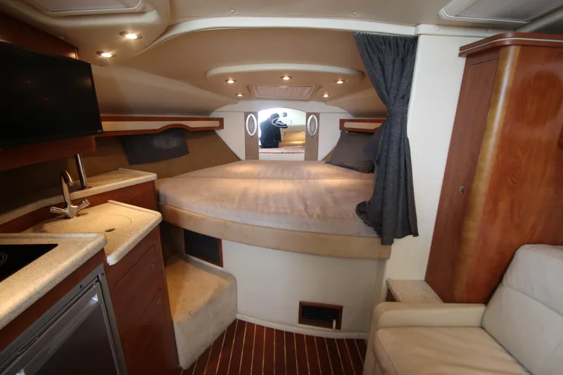 Slide: The Image of 2008 Rinker 330 Express Cruiser interior with bed, kitchenette, and seating area. - 24