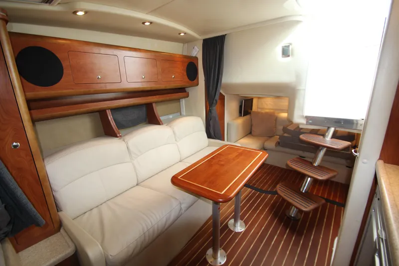 Slide: The Image of 2008 Rinker 330 Express Cruiser interior with wood accents and cozy seating area. - 27