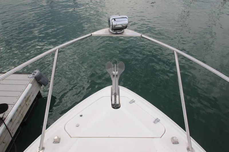 Slide: The Image of 2008 Rinker 330 Express Cruiser bow with anchor, docked on calm water. - 3