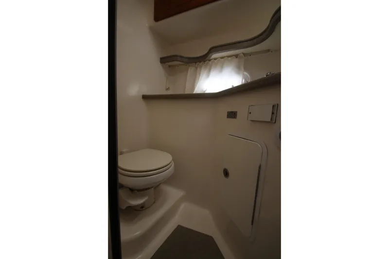 Slide: The Image of 2008 Rinker 330 Express Cruiser bathroom interior with toilet and storage. - 30