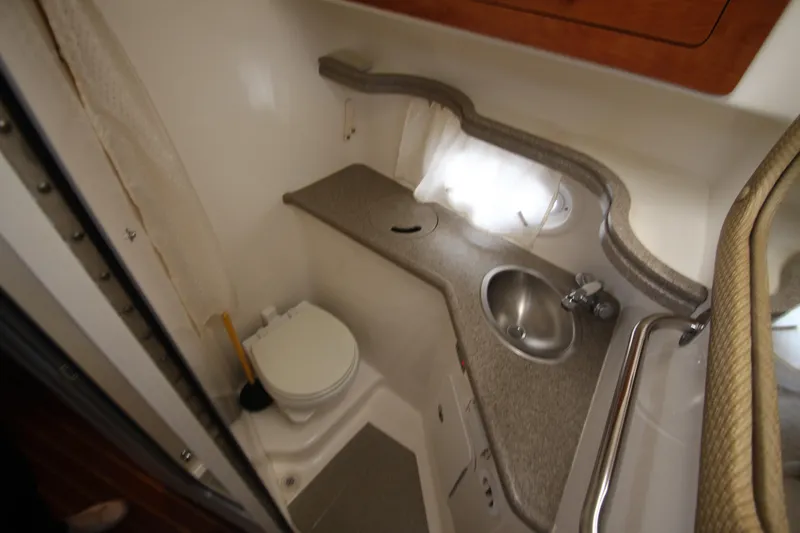 Slide: The Image of 2008 Rinker 330 Express Cruiser bathroom with toilet, sink, and countertop. - 32