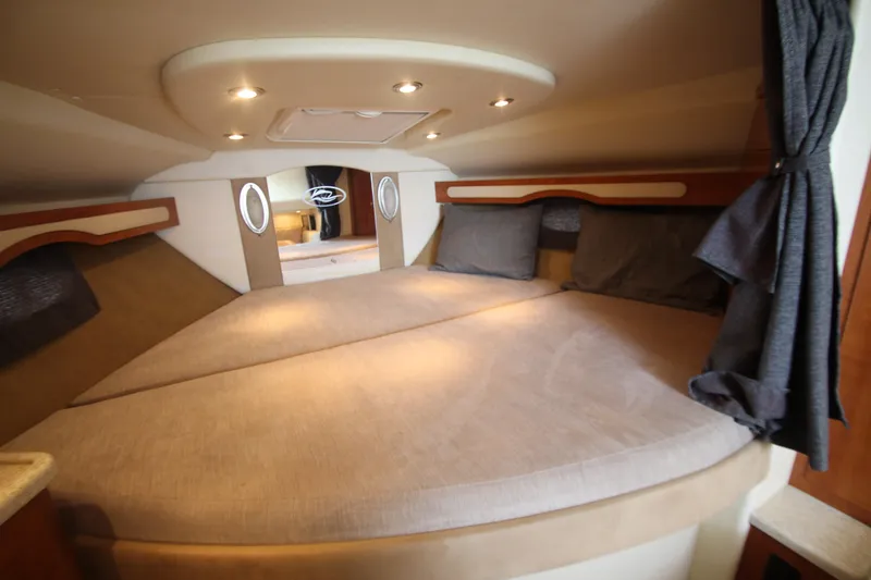 Slide: The Image of 2008 Rinker 330 Express Cruiser cabin interior with cozy bed and ambient lighting. - 34