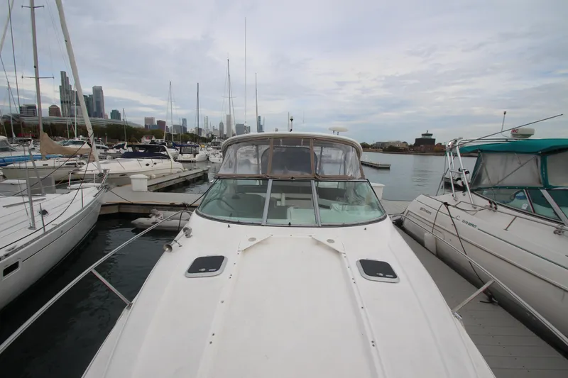 Slide: The Image of 2008 Rinker 330 Express Cruiser docked in a marina with city skyline background. - 4