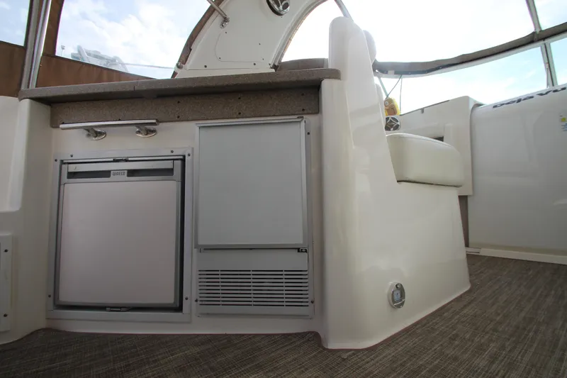 Slide: The Image of 2008 Rinker 330 Express Cruiser interior with compact fridge and seating area. - 42