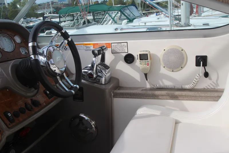 Slide: The Image of 2008 Rinker 330 Express Cruiser helm with steering wheel, controls, and communication equipment. - 51