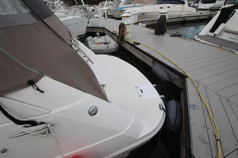 Slide: The Image of 2008 Rinker 330 Express Cruiser docked at marina with inflatable boat nearby. - 7