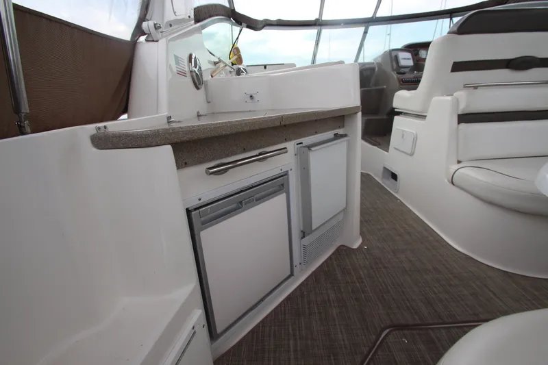Slide: The Image of 2008 Rinker 330 Express Cruiser interior with kitchenette and seating area. - 8