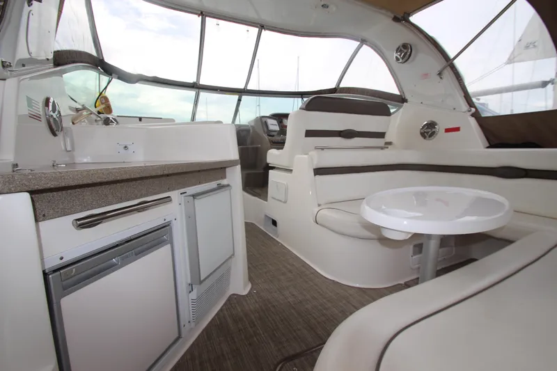 Slide: The Image of 2008 Rinker 330 Express Cruiser interior with seating, table, and kitchenette. - 9