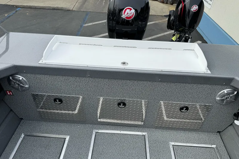 Slide: The Image of 2026 Lund 185 Heavy Gauge boat interior with storage compartments and dual outboard motors. - 14