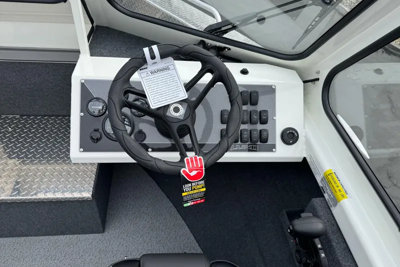 Slide: The Image of 2026 Lund 185 Heavy Gauge boat dashboard with steering wheel and control panel. - 25