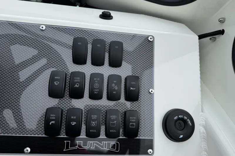 Slide: The Image of Control panel of 2026 Lund 185 Heavy Gauge boat with various switches and ignition. - 26