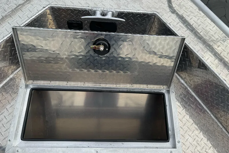 Slide: The Image of Open storage compartment on 2026 Lund 185 Heavy Gauge boat with diamond plate finish. - 29