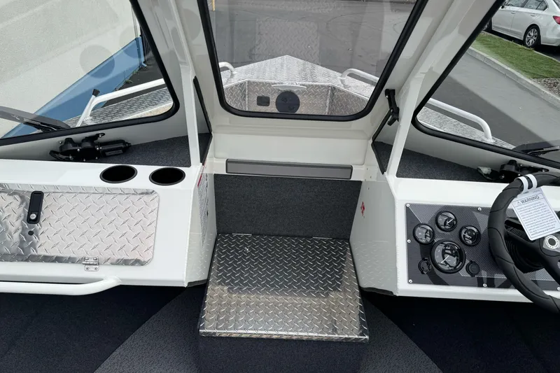 Slide: The Image of 2026 Lund 185 Heavy Gauge boat interior with steering wheel, dashboard, and diamond plate flooring. - 34