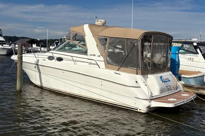 The Image of 2000 Sea Ray 310 Sundancer boat docked in marina, featuring beige canopy and sleek design. - 0