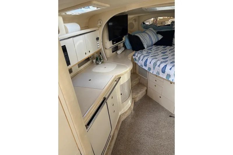 Slide: The Image of Interior of 2000 Sea Ray 310 Sundancer with kitchenette and cozy sleeping area. - 15
