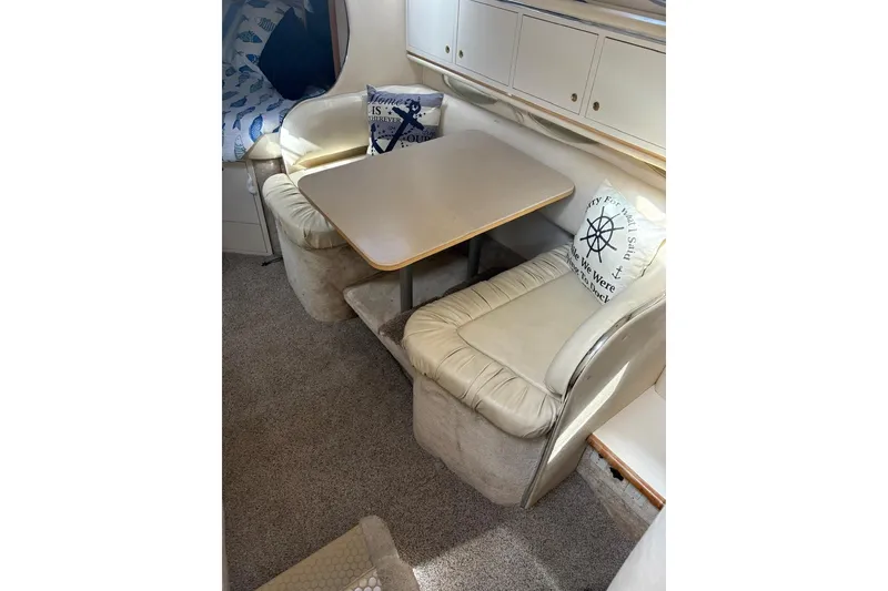 Slide: The Image of Interior of 2000 Sea Ray 310 Sundancer with cozy seating and nautical-themed pillows. - 17