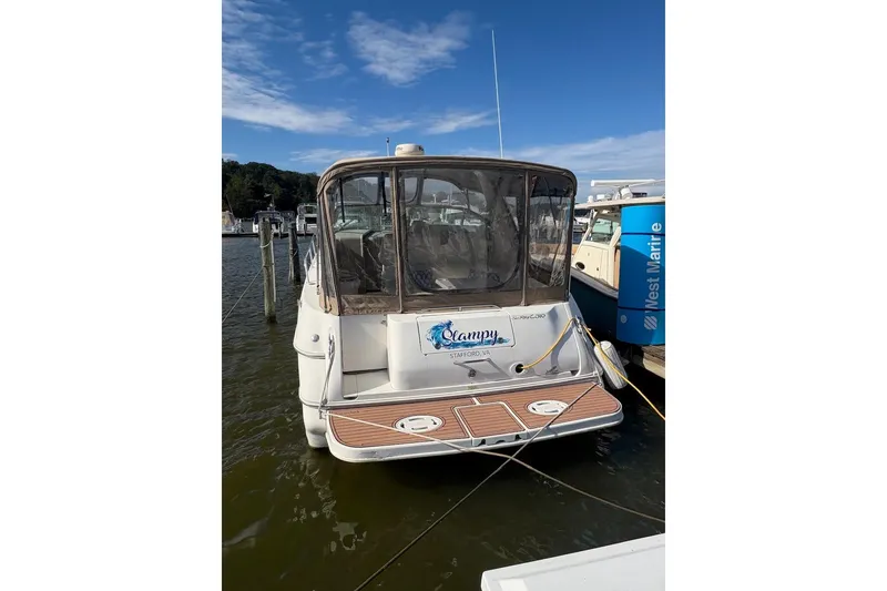Slide: The Image of 2000 Sea Ray 310 Sundancer docked at marina, rear view with clear skies. - 2