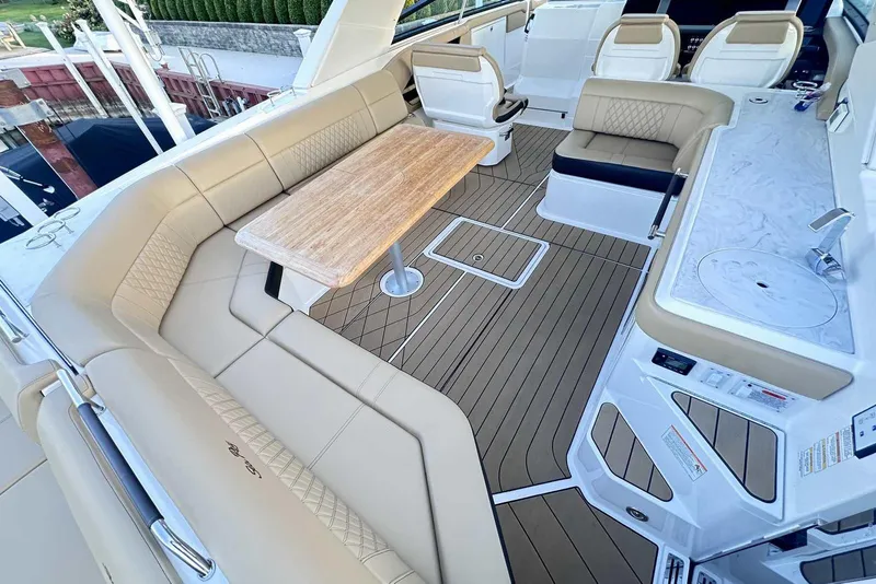 Slide: The Image of Luxurious 2024 Sea Ray SLX 400 yacht interior with elegant seating and wooden table. - 12