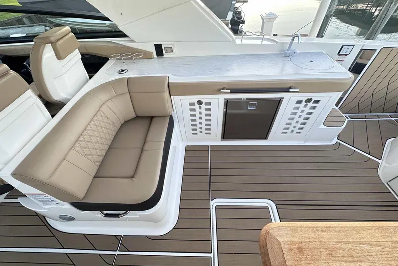 Slide: The Image of 2024 Sea Ray SLX 400 boat interior with seating, kitchenette, and wood flooring. - 17