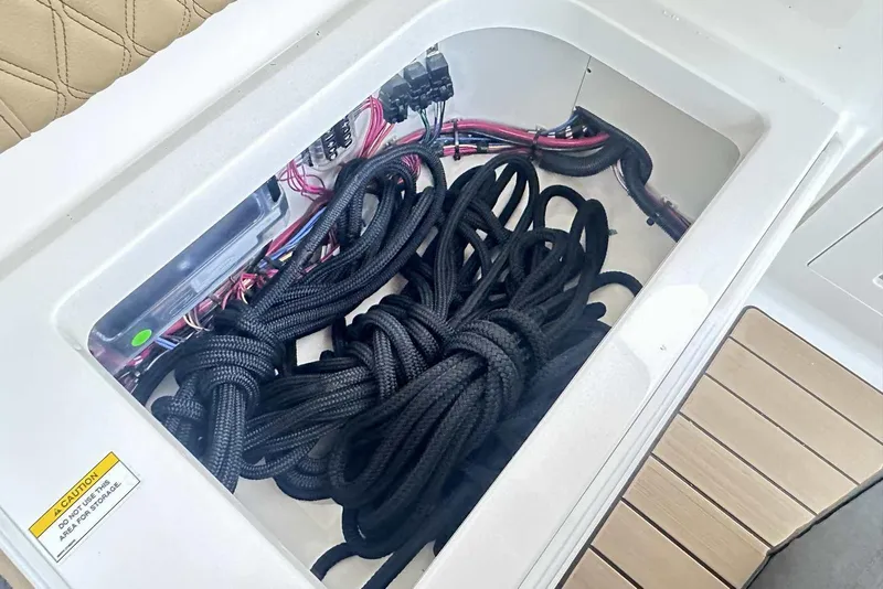 Slide: The Image of Storage compartment with ropes and wiring on a 2024 Sea Ray SLX 400 boat. - 18