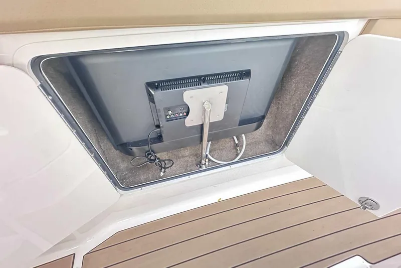 Slide: The Image of 2024 Sea Ray SLX 400 boat compartment with mounted TV and cables. - 31