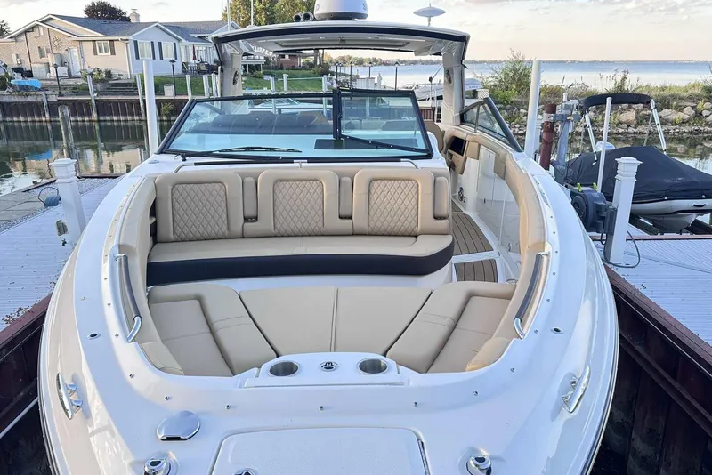 Slide: The Image of 2024 Sea Ray SLX 400 boat with luxurious seating, docked by a serene waterfront. - 4