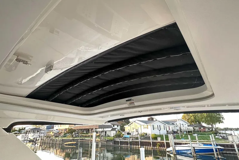 Slide: The Image of 2024 Sea Ray SLX 400 sunroof view with waterfront background. - 40