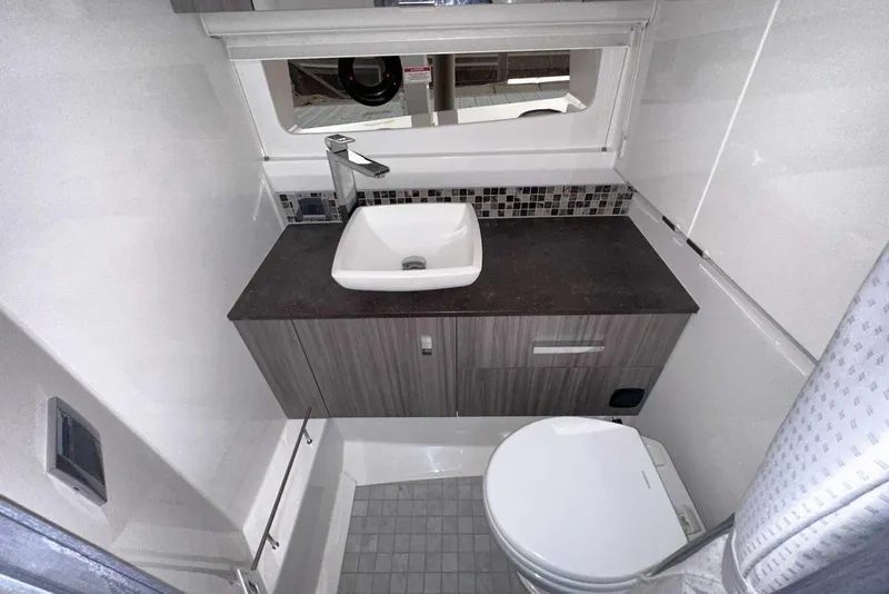 Slide: The Image of 2024 Sea Ray SLX 400 bathroom with modern sink, toilet, and sleek design. - 54