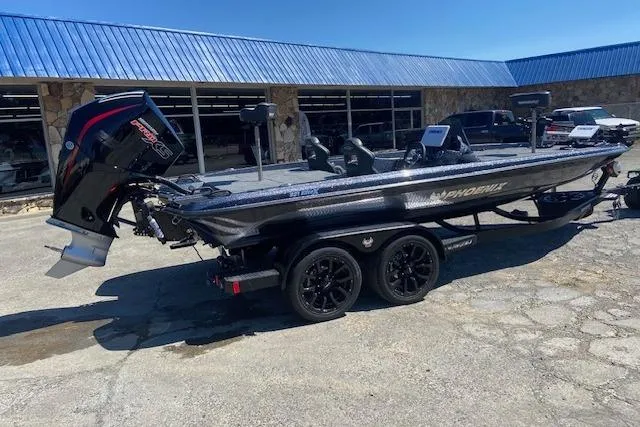 The Image of 2026 Phoenix 921 ELITE boat on trailer, parked outside a building with blue roof. - 1