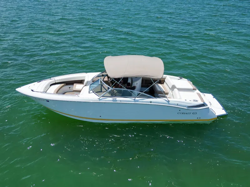 Slide: The Image of 2013 Cobalt 296 boat on clear green water, featuring a sleek design and canopy. - 4