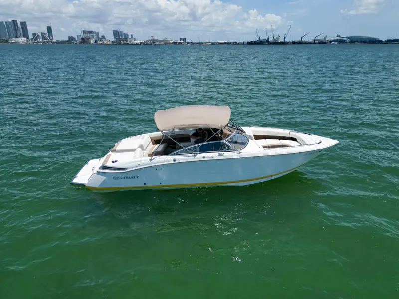 Slide: The Image of 2013 Cobalt 296 boat on calm water with city skyline in background. - 6