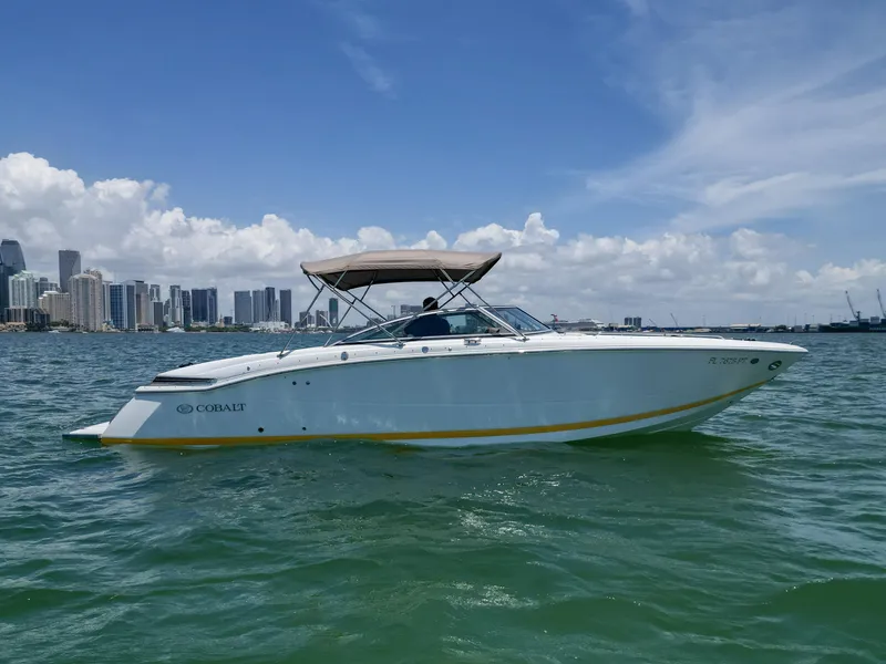 Slide: The Image of 2013 Cobalt 296 boat cruising on water with city skyline in background. - 9