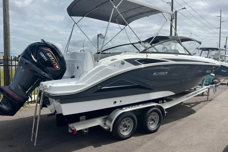 The Image of 2026 Hurricane SunDeck 235 OB boat on trailer with Yamaha engine, parked outdoors. - 0
