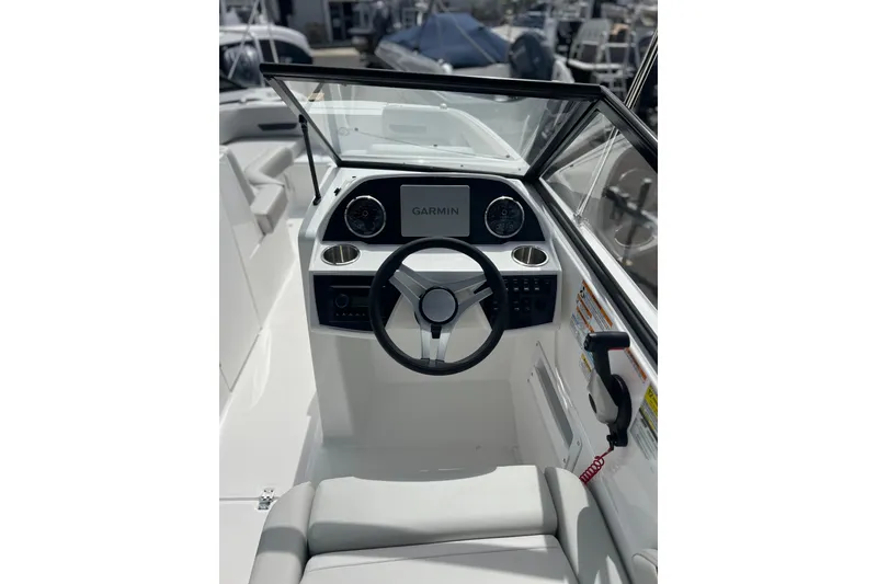 Slide: The Image of 2026 Hurricane SunDeck 235 OB boat cockpit with Garmin navigation system and steering wheel. - 4