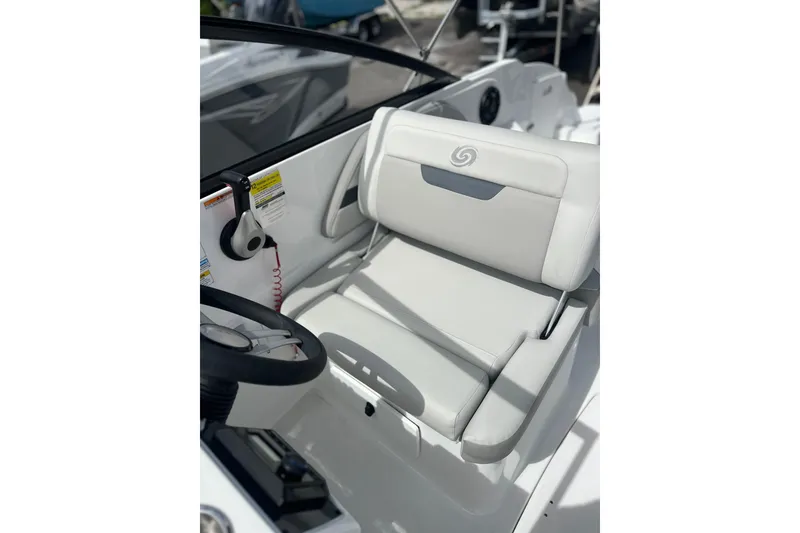 Slide: The Image of 2026 Hurricane SunDeck 235 OB boat interior with steering wheel and cushioned seating. - 5
