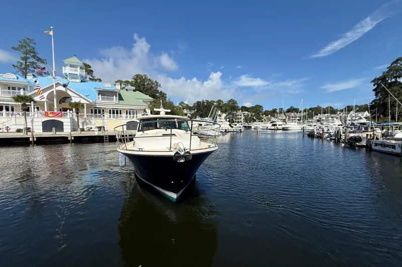 Slide: The Image of 2023 Sabre 43 Salon Express yacht docked at a scenic marina under a clear blue sky. - 10