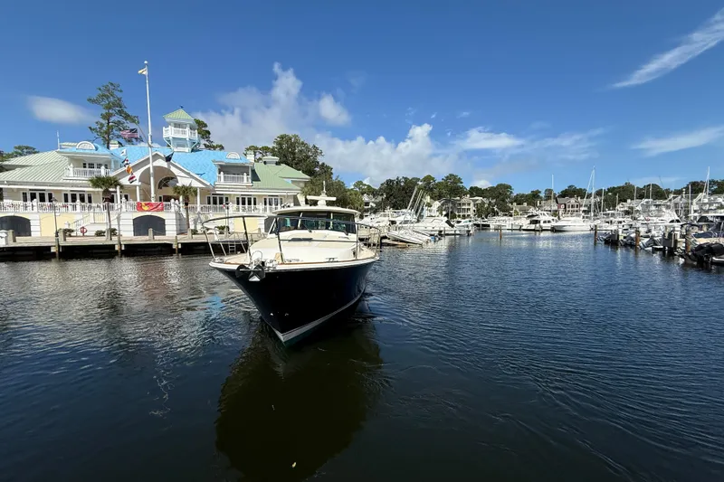 Slide: The Image of 2023 Sabre 43 Salon Express yacht docked at a marina under a clear blue sky. - 11