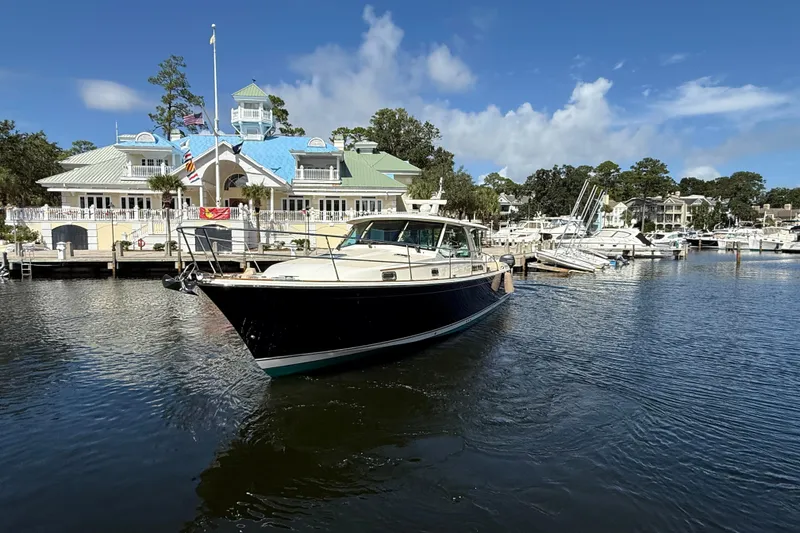 Slide: The Image of 2023 Sabre 43 Salon Express yacht docked at a marina with scenic background. - 12