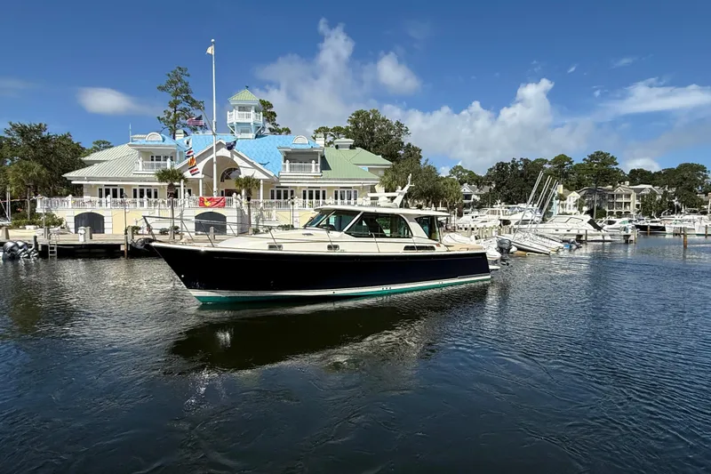 Slide: The Image of 2023 Sabre 43 Salon Express yacht docked at a marina with scenic background. - 13