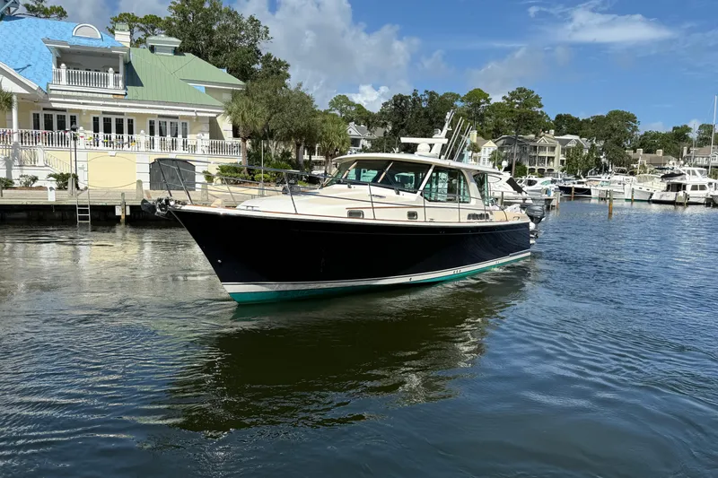 Slide: The Image of 2023 Sabre 43 Salon Express yacht docked in a scenic marina setting. - 14