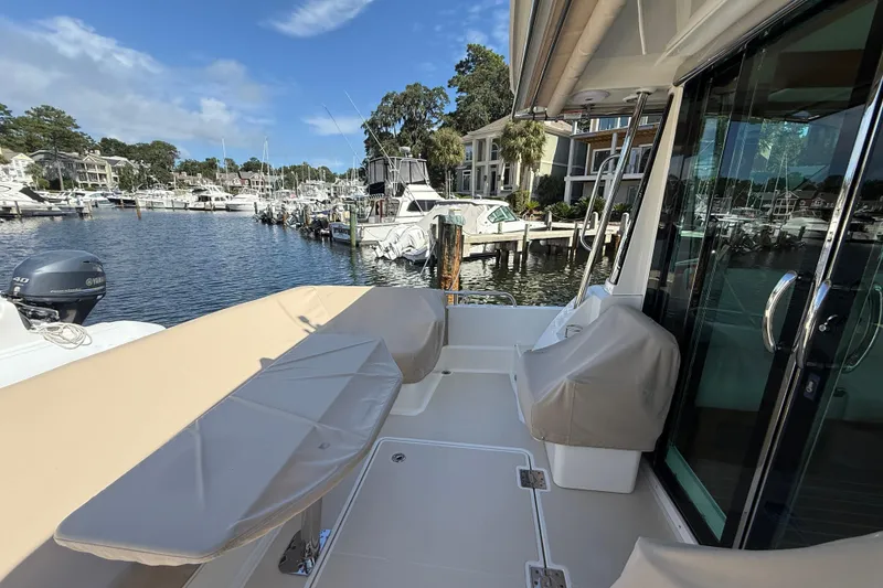 Slide: The Image of 2023 Sabre 43 Salon Express yacht docked at a marina, showcasing its spacious deck. - 17