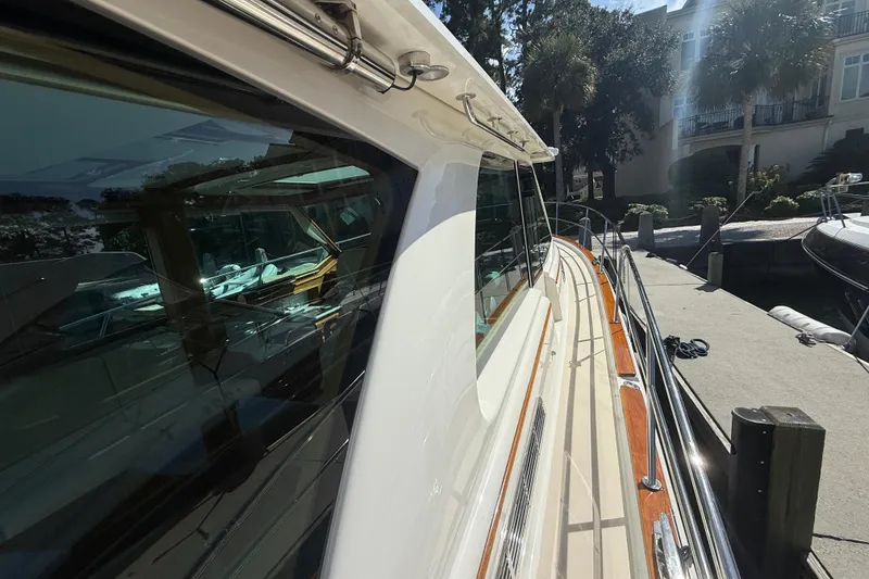 Slide: The Image of 2023 Sabre 43 Salon Express yacht docked, showcasing sleek design and reflective windows. - 20