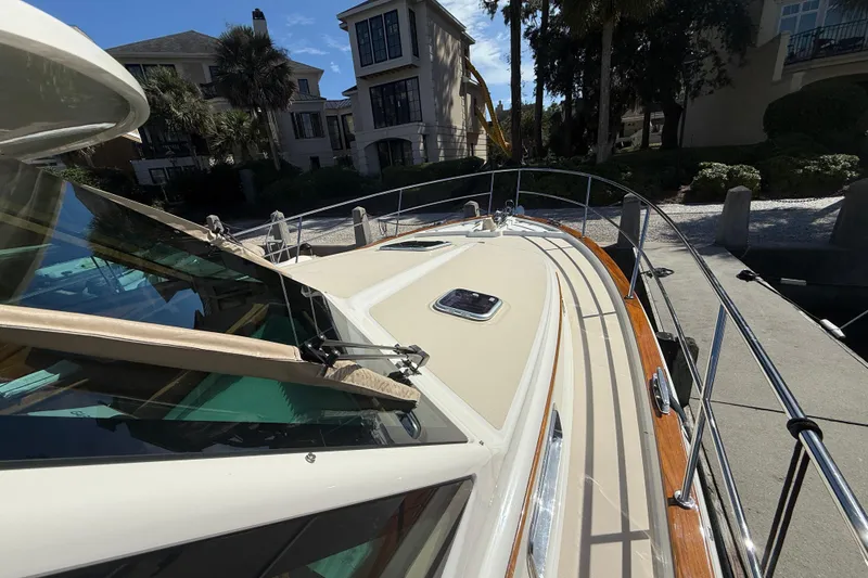 Slide: The Image of 2023 Sabre 43 Salon Express yacht docked near luxury waterfront homes. - 23