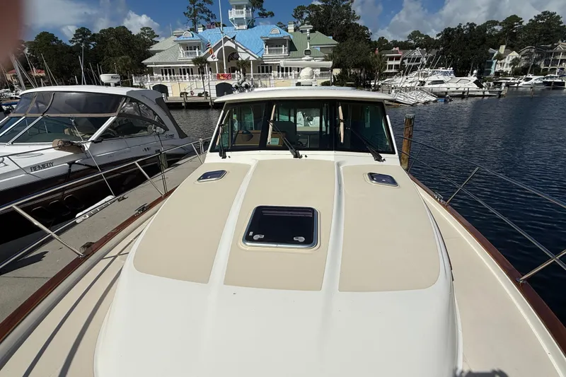 Slide: The Image of 2023 Sabre 43 Salon Express yacht docked at a marina with scenic background. - 28
