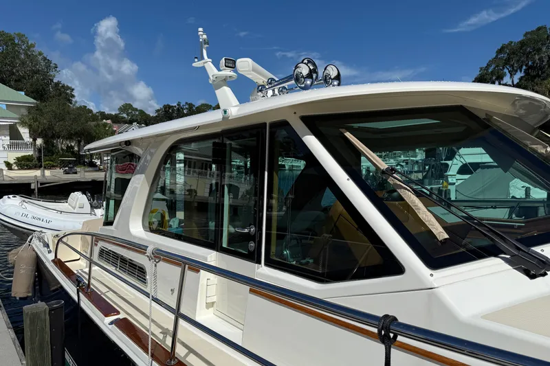 Slide: The Image of 2023 Sabre 43 Salon Express yacht docked at marina under clear blue sky. - 29