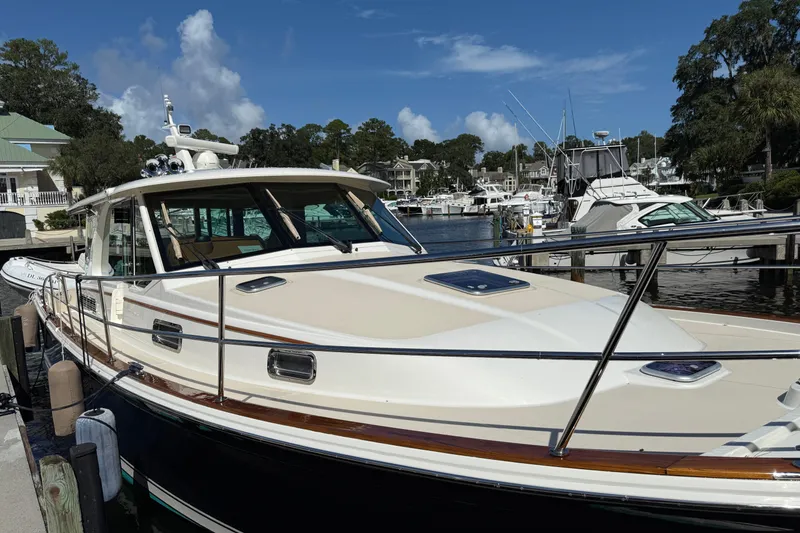 Slide: The Image of 2023 Sabre 43 Salon Express yacht docked at a marina under a clear blue sky. - 30